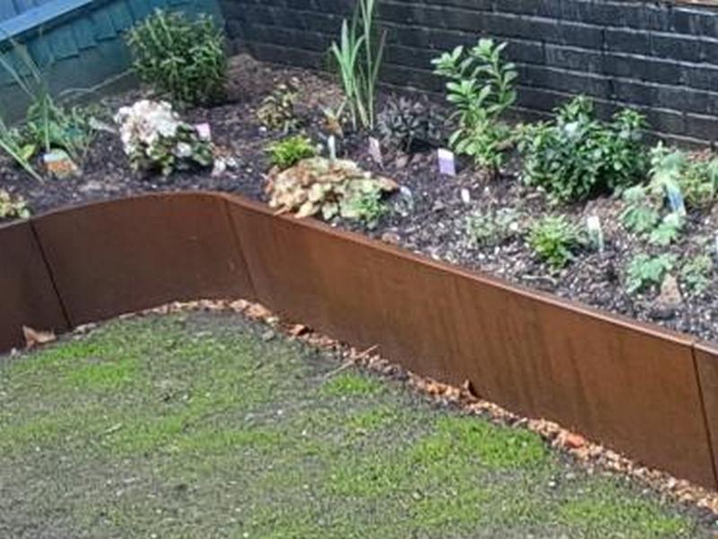 Subtle color shifts of a corten retaining wall in the afternoon sun.