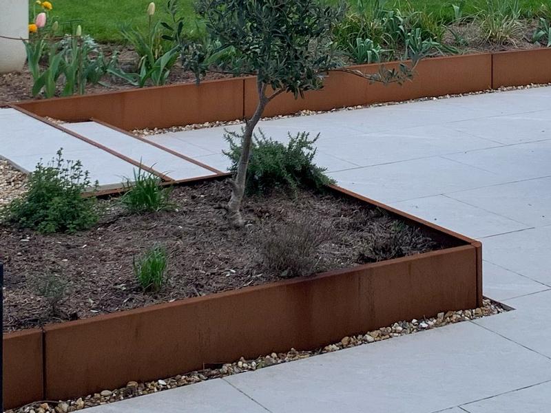 Matte, velvet-like texture of a fully seasoned corten steel retaining wall.