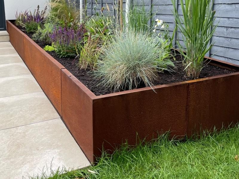 Tiered corten steel retaining wall system on a steep suburban block.